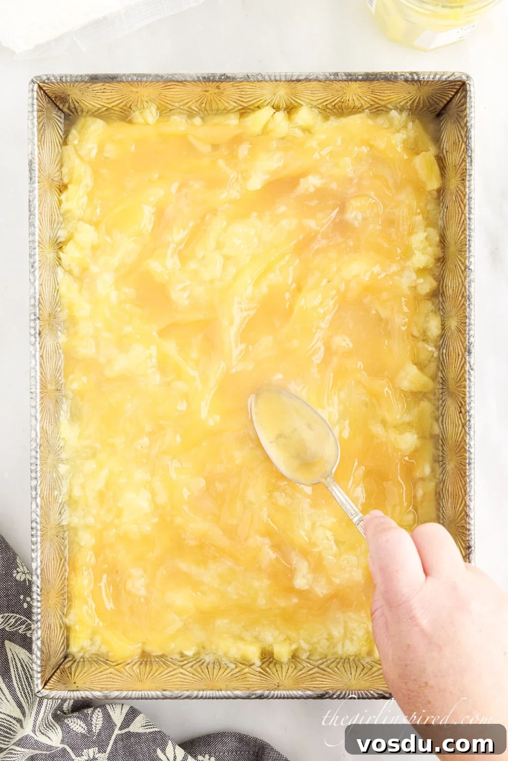 Tangy Lemon Pineapple Dump Cake Recipe for Summer Dessert 6 Pineapple ingredients and lemon curd being spread into baking pan.