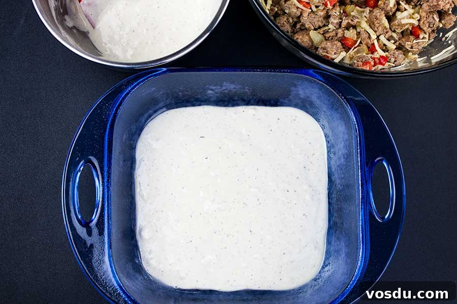 Savory Sausage Breakfast Cake Recipe for Brunch and Meal Prep 3 Sausage Breakfast Cake Recipe - first layer of batter in the bottom of a blue glass pan