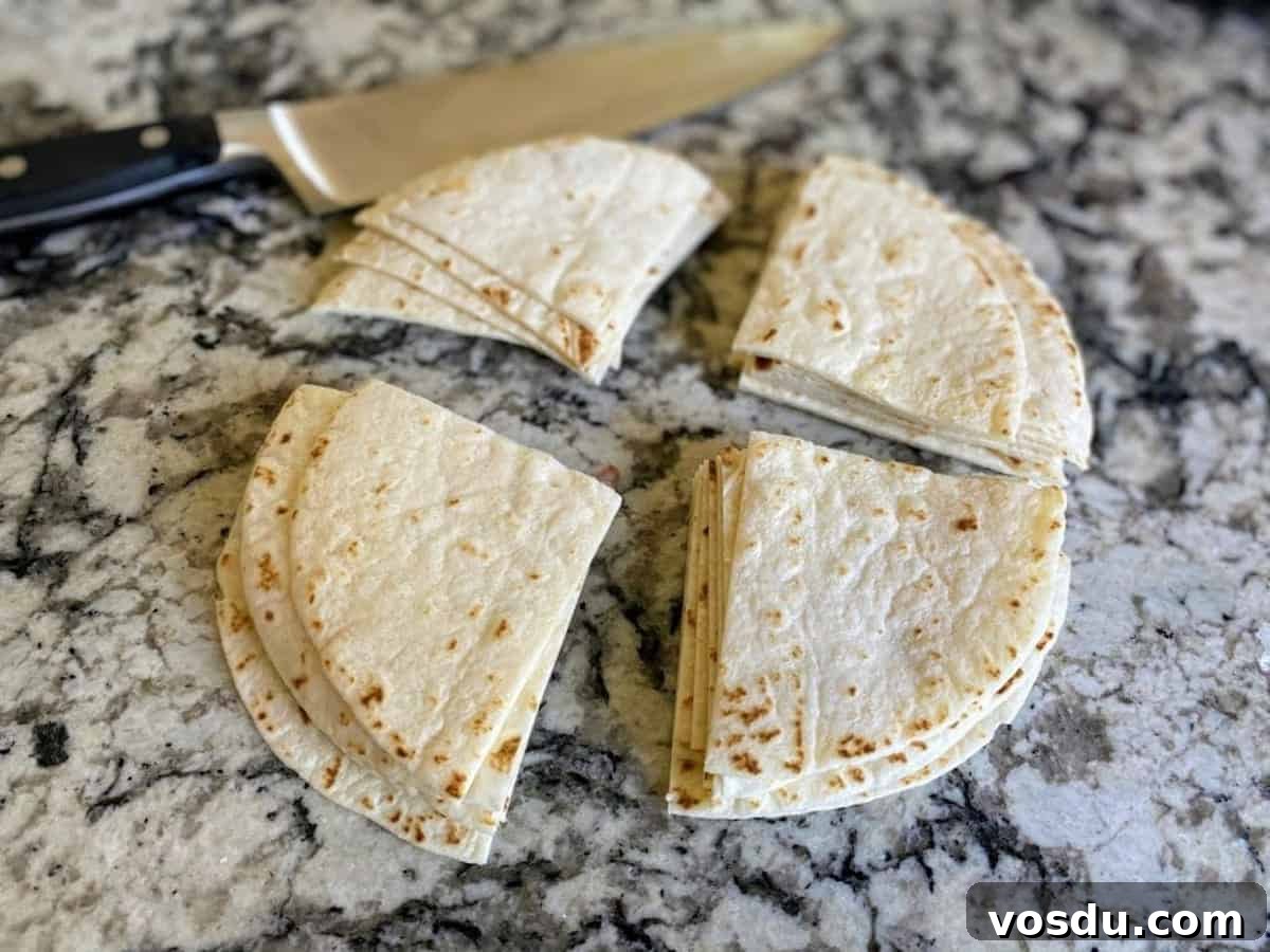 Crunchy Vegan Nachos with Spicy Cashew Cheese 3 Cut tortillas on a counter with a knife