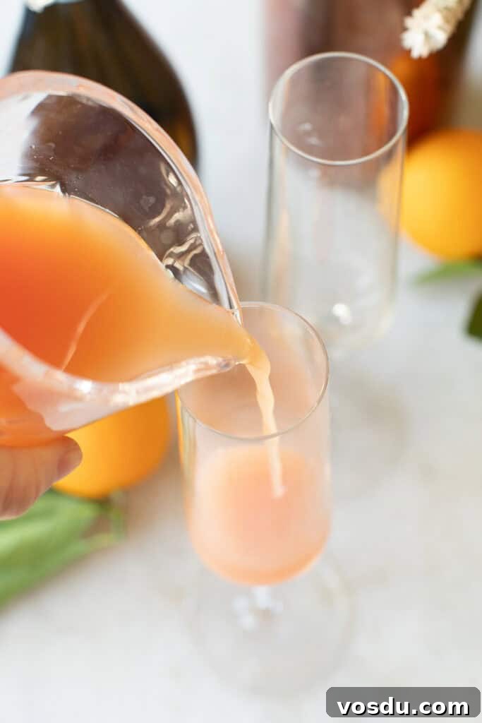 Citrus Grapefruit Mimosa Recipe — Bright Brunch Cocktail 4 Pouring grapefruit into a Champagne glass.
