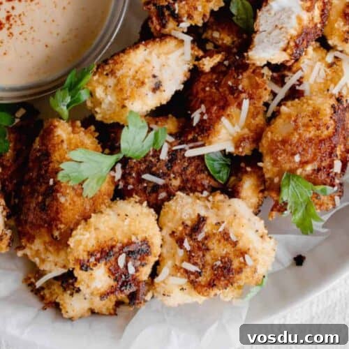 Fried chicken nuggets with dipping sauce served on a plate.