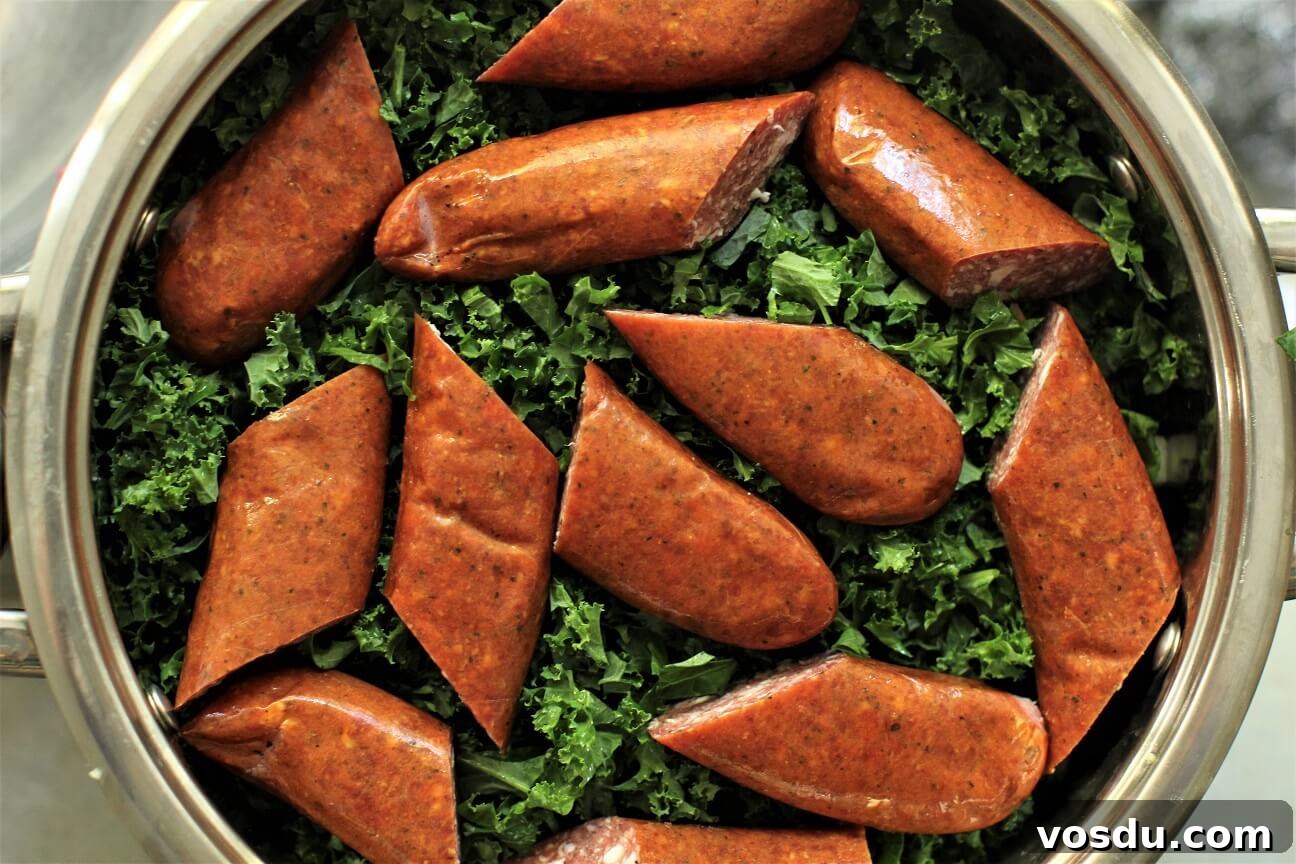 Dutch Kale Stamppot with Sausage — Classic Dutch Comfort Meal 8 sausage pieces laying on top of the chopped kale in the pot