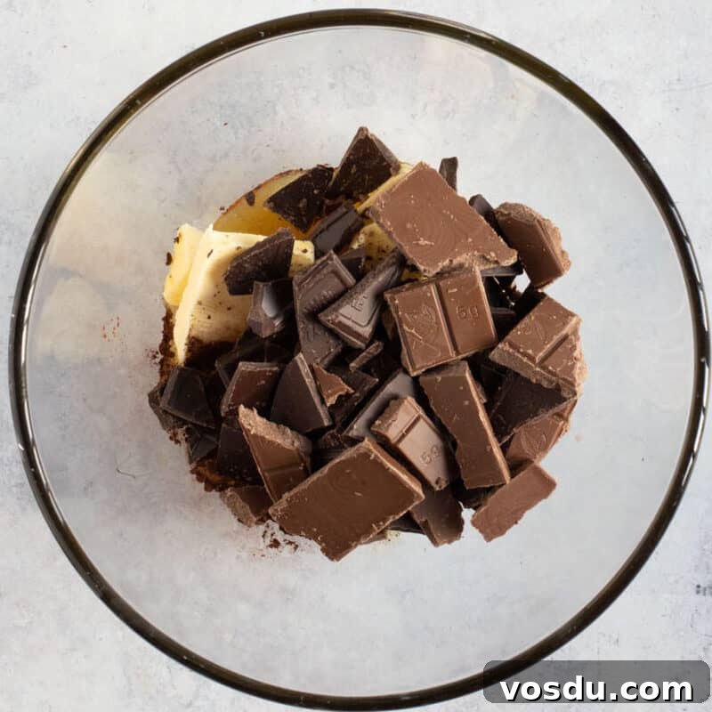 No-Bake Chocolate Oreo Tiffin Recipe — Quick No-Bake Dessert 5 Chocolate, butter and syrup in a bowl.