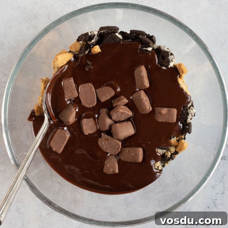No-Bake Chocolate Oreo Tiffin Recipe — Quick No-Bake Dessert 6 Melted chocolate mixed with crushed biscuits in a bowl.