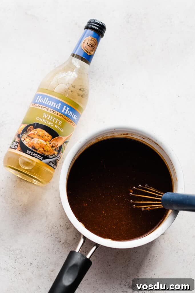 Slow Cooker Honey Garlic Chicken Recipe for Tender, Flavorful Meat 6 A bottle of white cooking wine next to a saucepan of sauce.