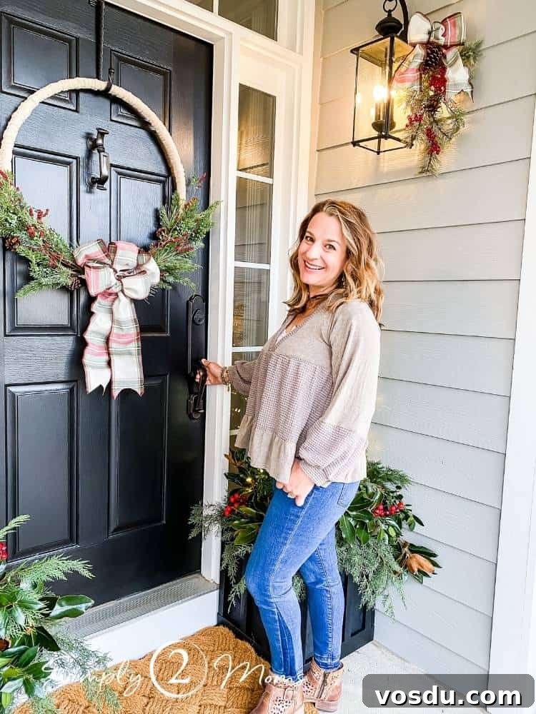 Country Chic Christmas Home Tour That Inspires Holiday Decorating 2 A woman stands in front of her front door on a porch decorated for Christmas