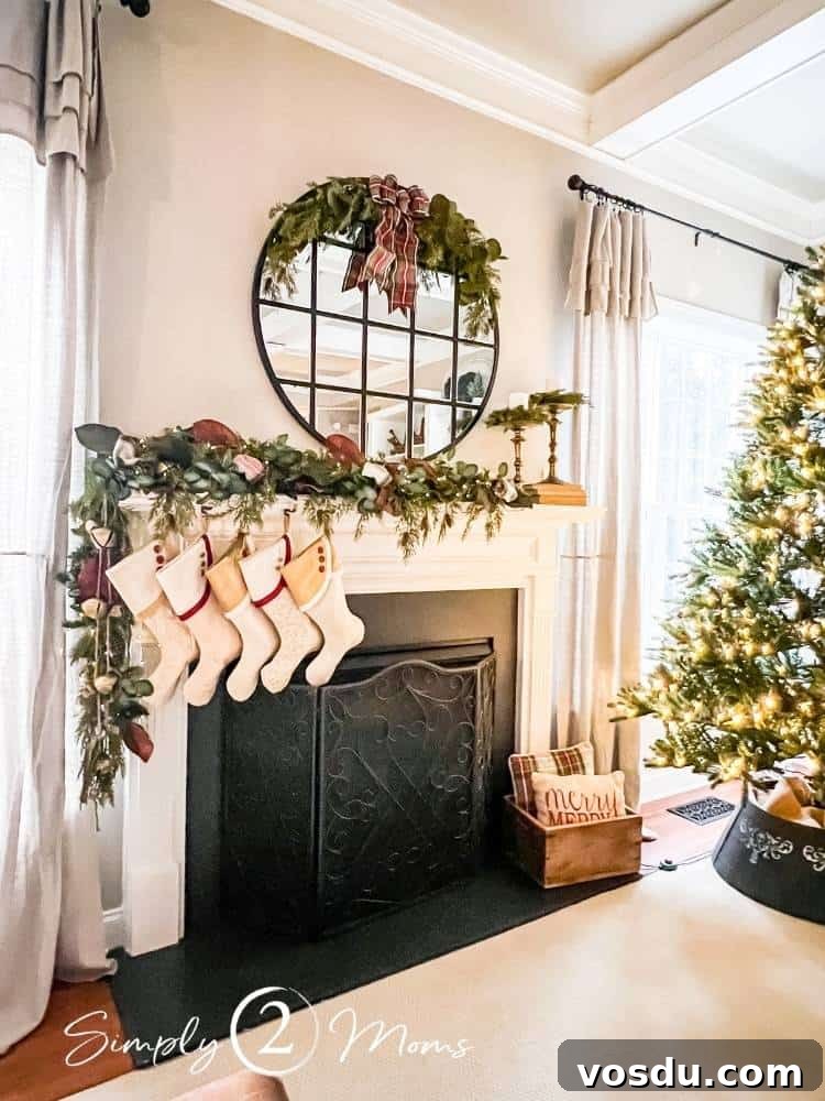 Country Chic Christmas Home Tour That Inspires Holiday Decorating 15 Gas fireplace with painted marble surround decorated for Christmas with natural greenery garland, custom South House Design stockings, with a large round mirror decorated with a half wreath.
