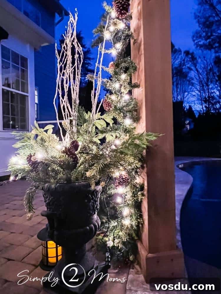 Country Chic Christmas Home Tour That Inspires Holiday Decorating 25 Black French country urn with greenery and Christmas lights and painted wood sticks in the center sitting next to a pool