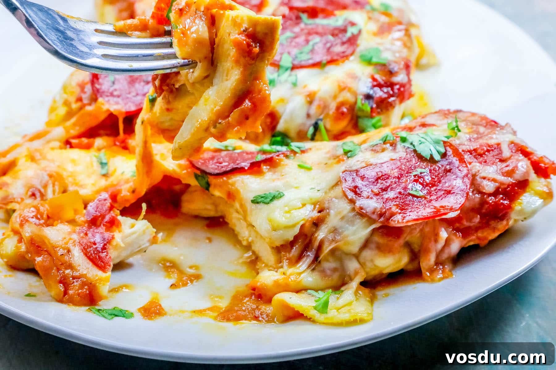 Keto Low-Carb Cheesy Pizza Chicken Recipe 7 chicken smothered in cheese and pepperonis on a plate