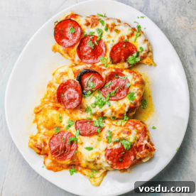 Keto Low-Carb Cheesy Pizza Chicken Recipe 9 A plate of Cheesy Pizza Chicken garnished with herbs.
