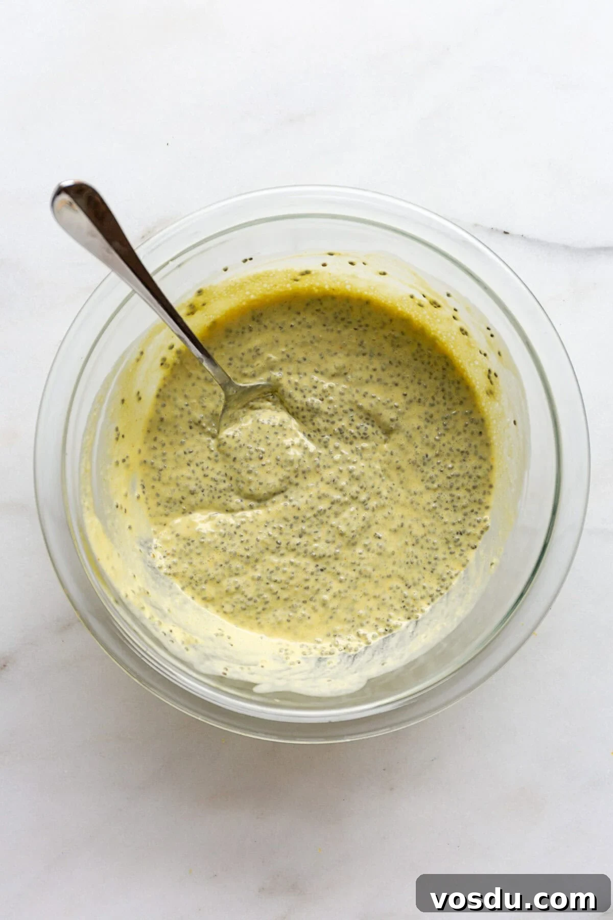 Creamy Lemon Chia Pudding Recipe for Bright Morning Meals 8 Lemon chia pudding in a mixing bowl with a spoon.