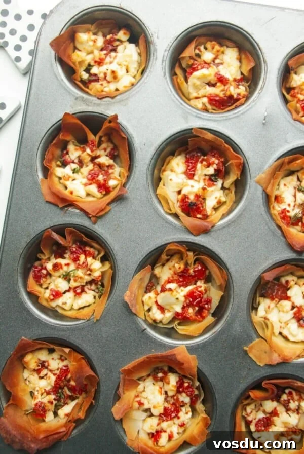 Blue Cheese, Prosciutto & Sweet Chili Filo Cups Recipe 10 Close up of baked sundried tomato feta cups in a mini muffin tin.