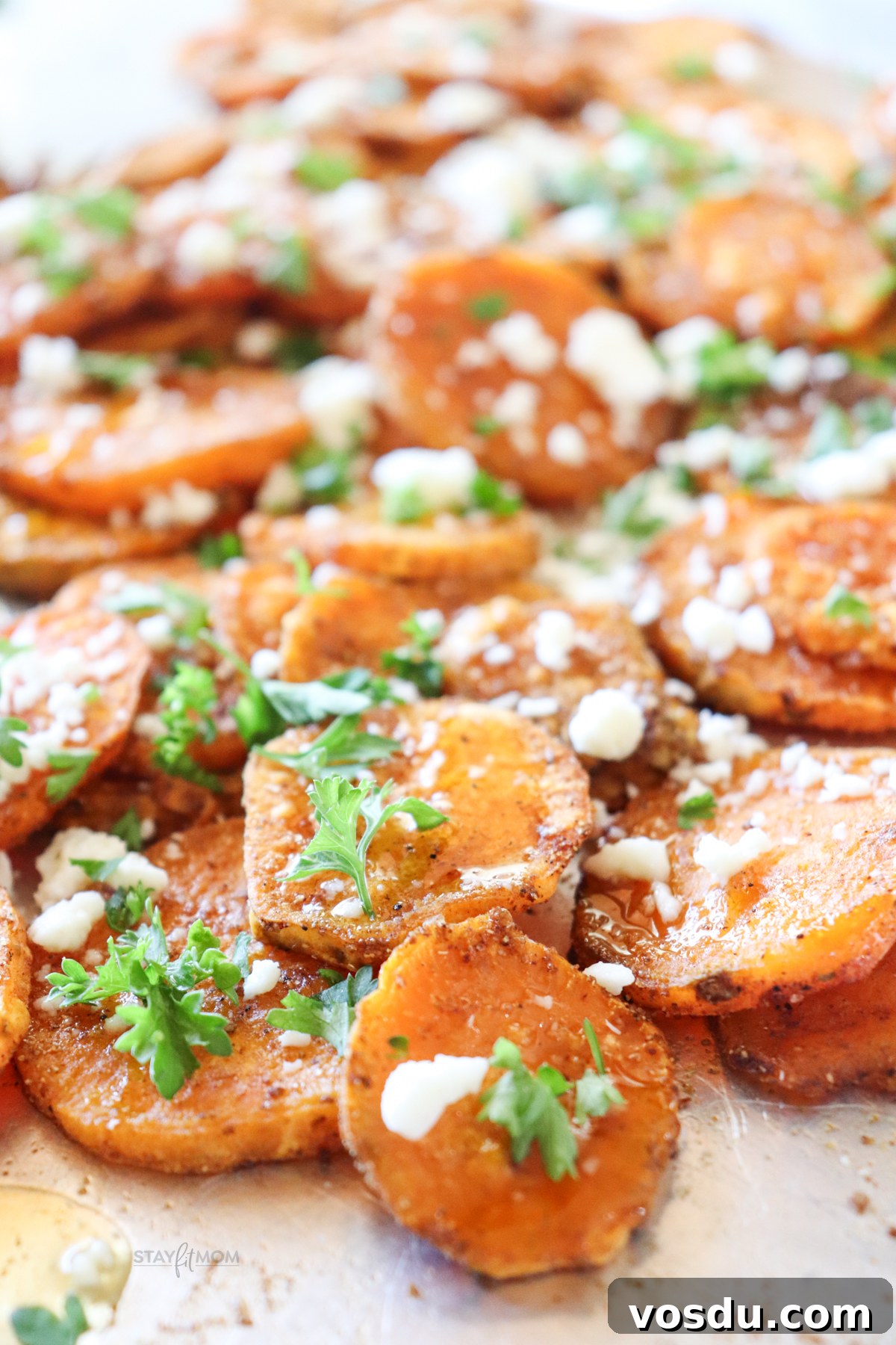 Honey-Roasted Sweet Potato Rounds with Maple Glaze 2 Honey roasted sweet potato rounds showing finished recipe with roasted sweet potatoes, topped with a glaze, feta, and some parsley.