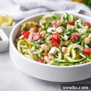 Zucchini Noodle Salad with White Beans, Feta & Lemon Vinaigrette 6 Zucchini noodle salad in white bowl with tomatoes, feta, and beans.