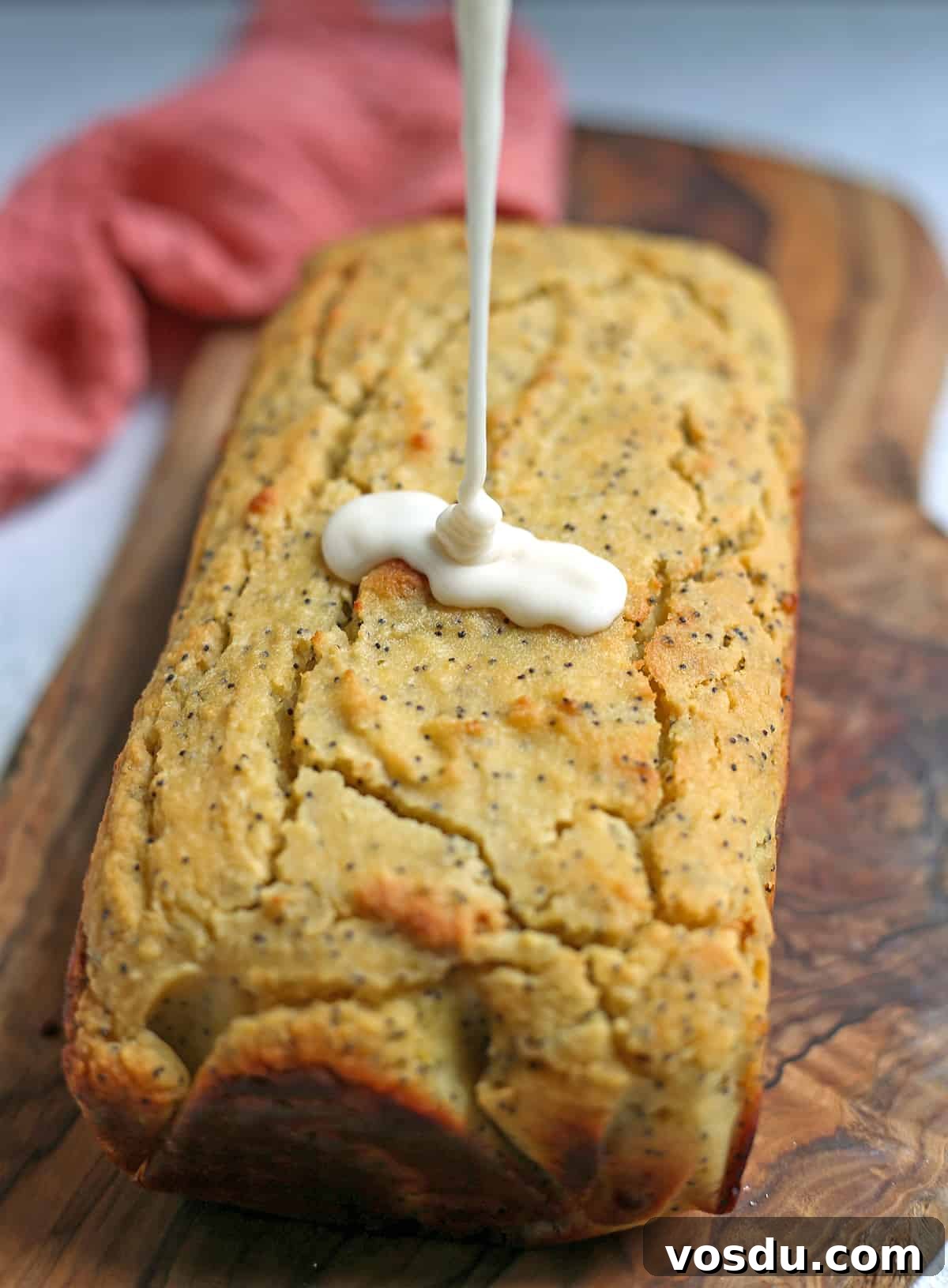 Glaze being poured over lemon bread.