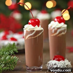 Decadent Raspberry White Hot Chocolate Recipe 3 Two small glasses of Cherry Hot Chocolate with fir in the background.