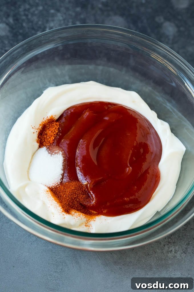 Fry Sauce Recipe #sauce #dinneratthezoo Mayonnaise, ketchup and spices in a mixing bowl.