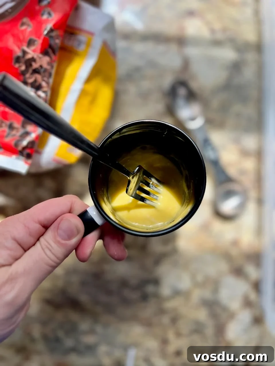 Sourdough Mug Cookie Recipe: Quick Single-Serve Treat 4 Mixing wet ingredients for a sourdough cookie in a mug using a fork until smooth.