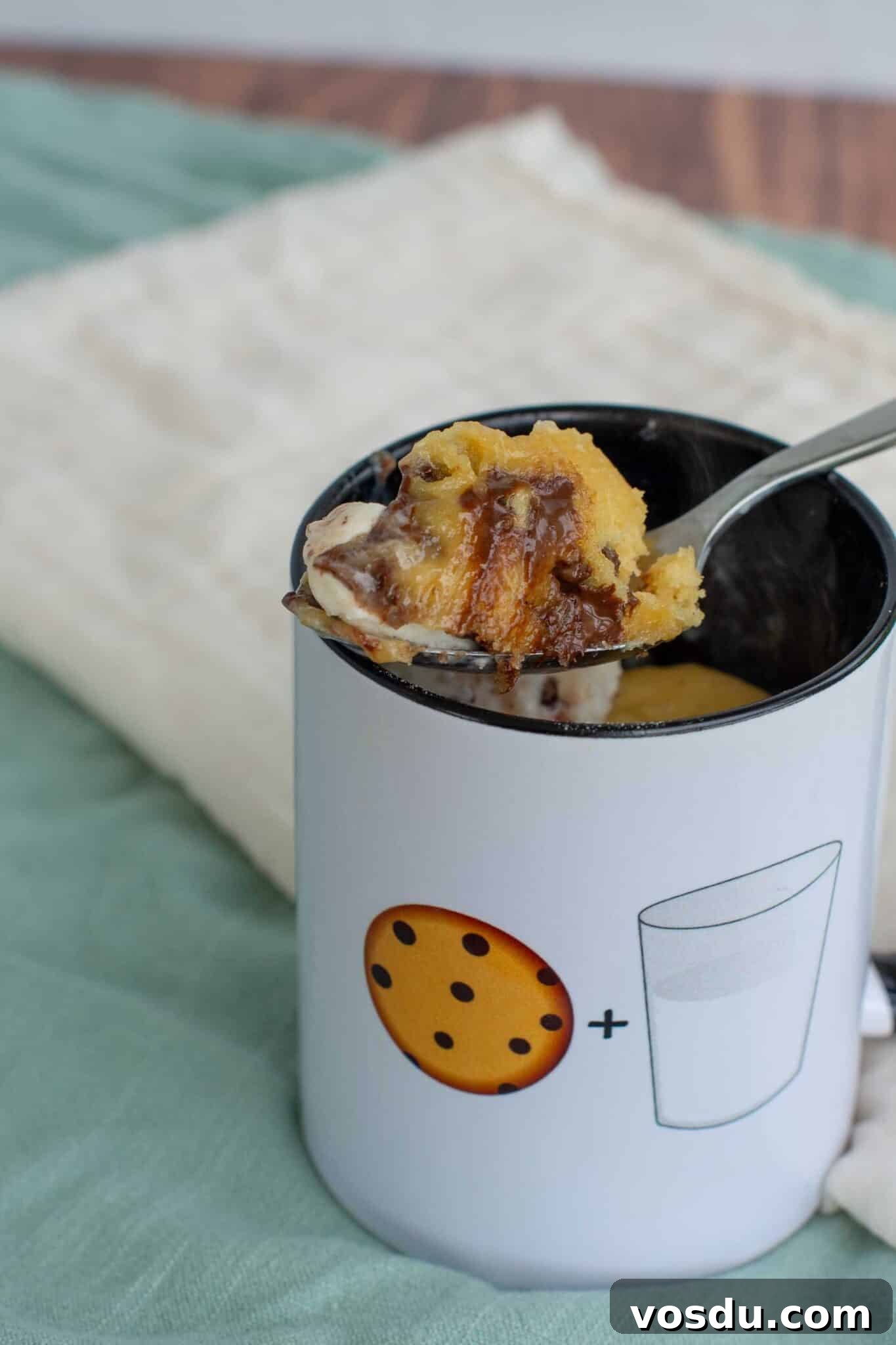 Sourdough Mug Cookie Recipe: Quick Single-Serve Treat 9 Close-up of a warm sourdough cookie in a mug with a spoon lifting a gooey, chocolate-filled bite, topped with melting ice cream.