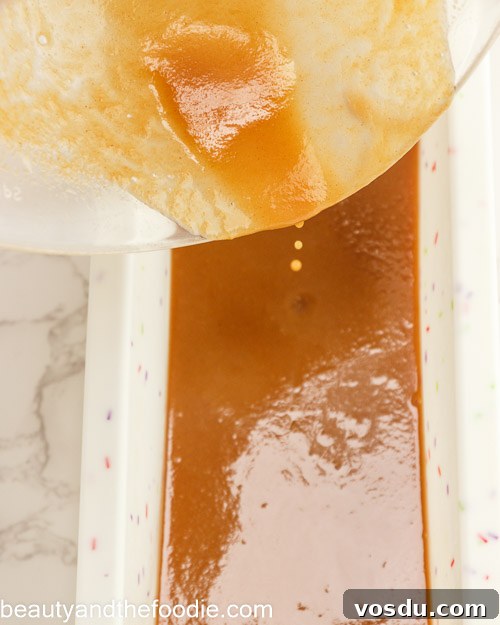 Keto Payday Candy Bar Recipe: Low-Carb Payday-Style Treat 10 Pouring the caramel into a loaf pan.