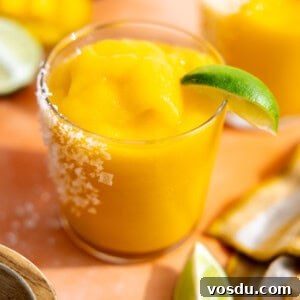 Frozen mango margarita served with a lime wedge.