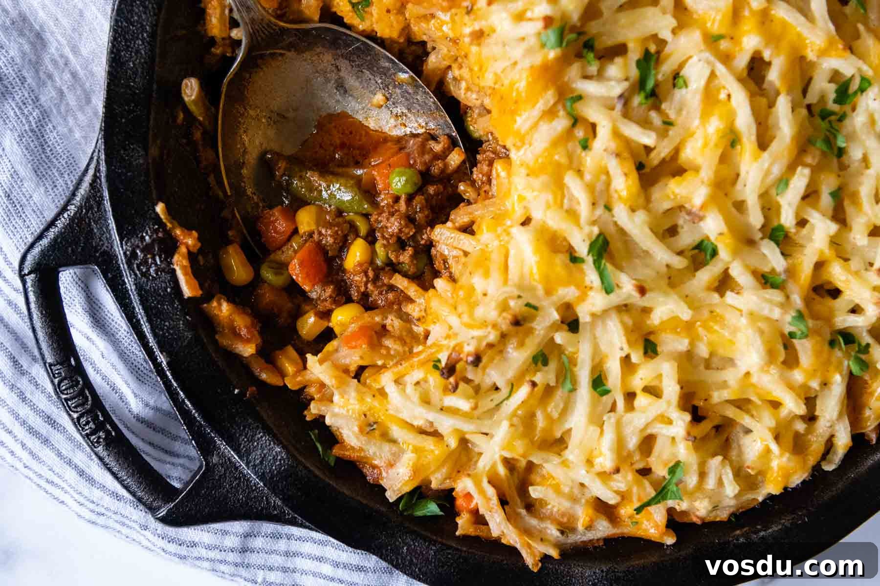 overhead of shepherds pie with a spoon going into dish.