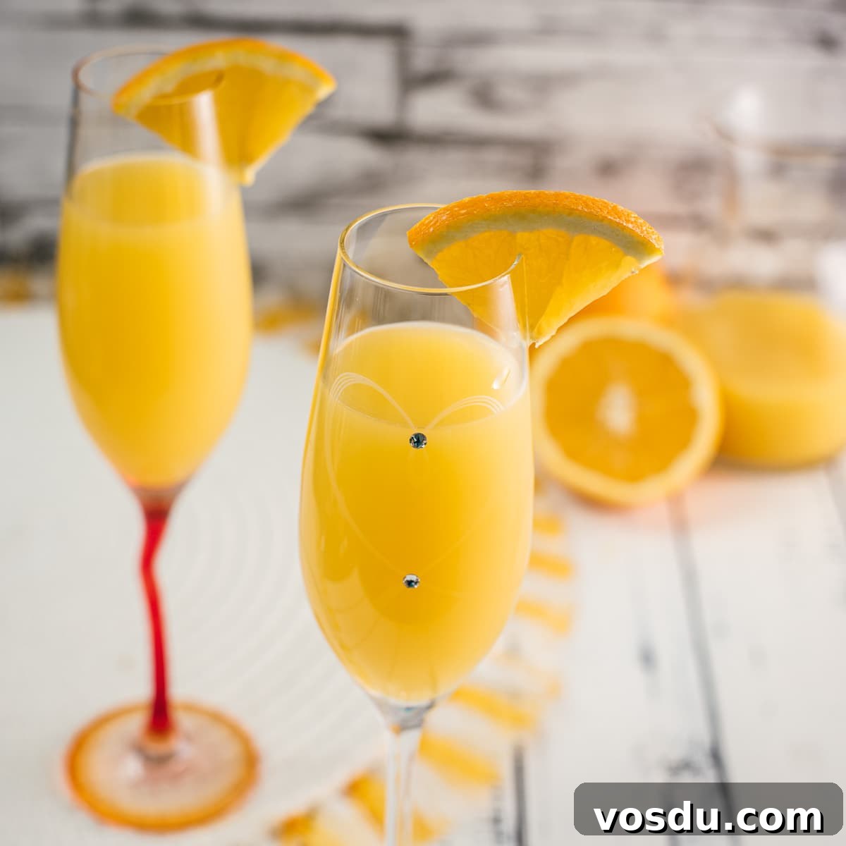 Gorgeous mimosa, garnished with orange slice in cute glass with small gems.