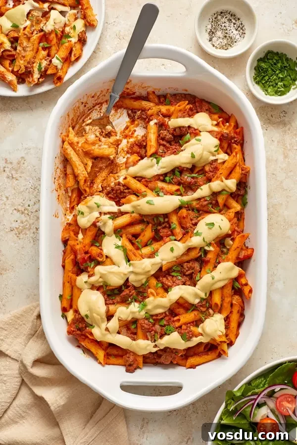 Dairy-Free Baked Ziti with Creamy Cashew Sauce 6 A tray of Gluten Free Dairy Free Baked Ziti with salad and spices to the side.