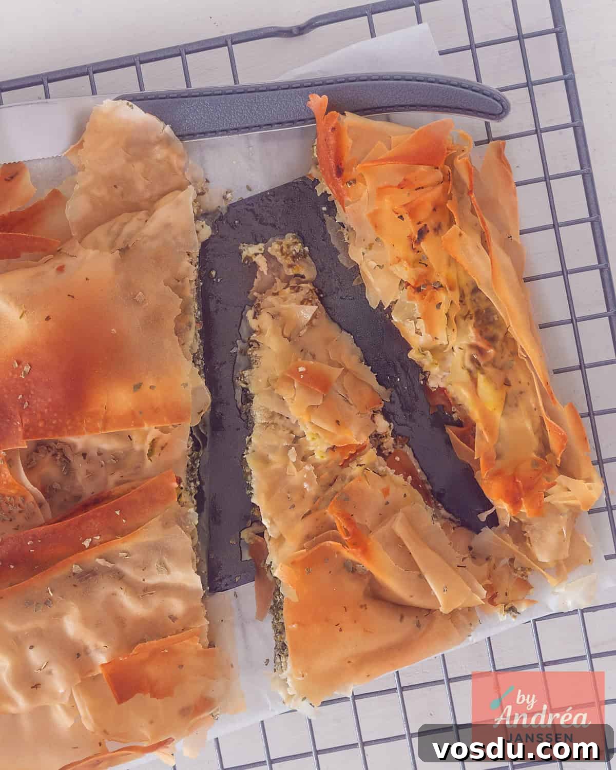 An overhead photo of a sliced ​​ricotta, spinach, and feta filo pastry cake.