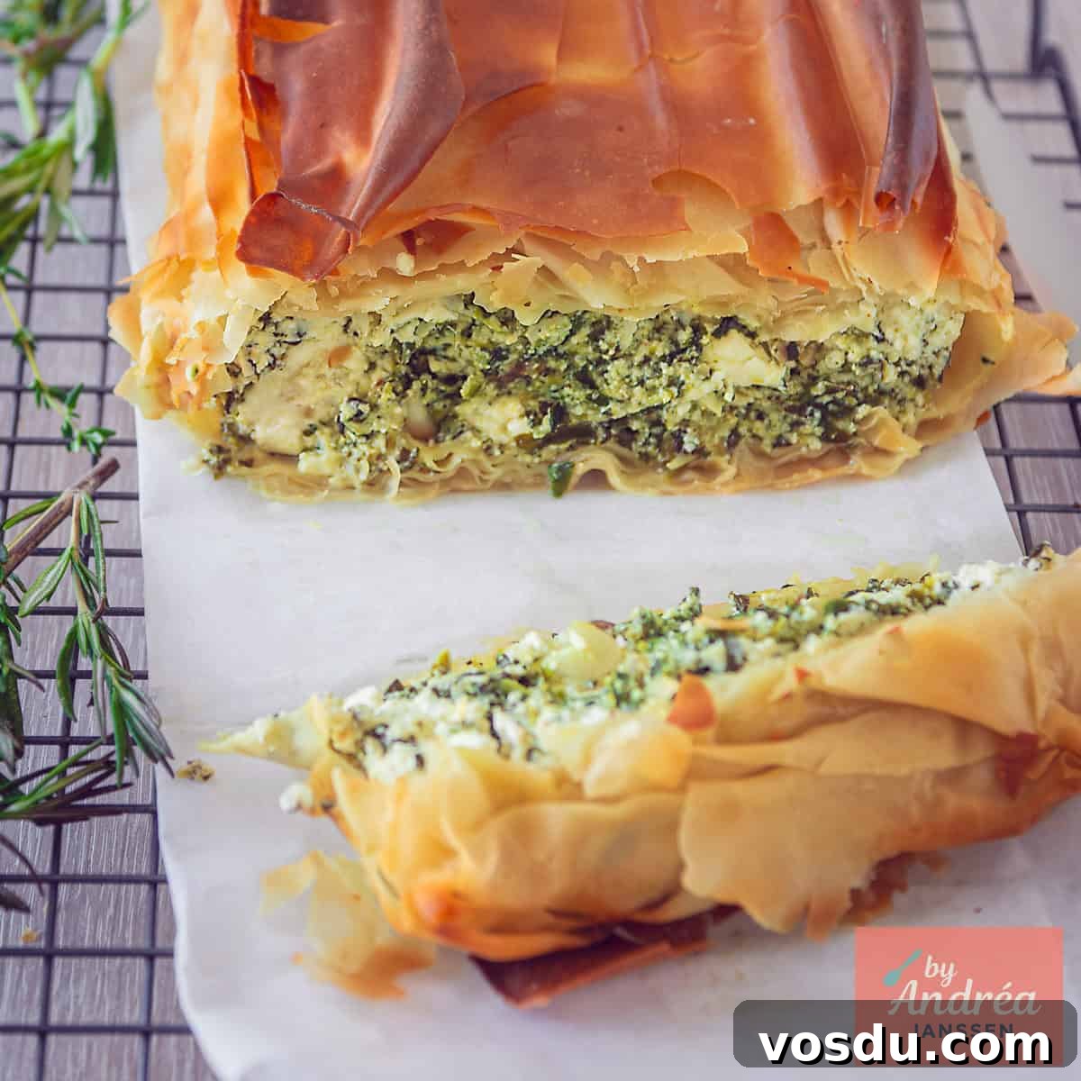 A square photo of a portion of a savory pie, clearly showing the filling (feta, spinach, and ricotta)
