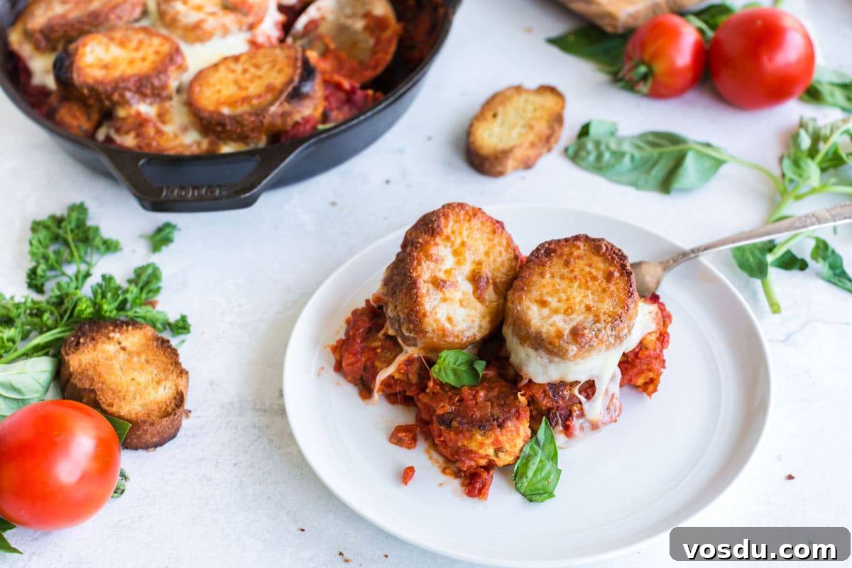 Cheesy Chicken Meatball Casserole with Tomato Basil Sauce 11 Platter of food served from iron skillet