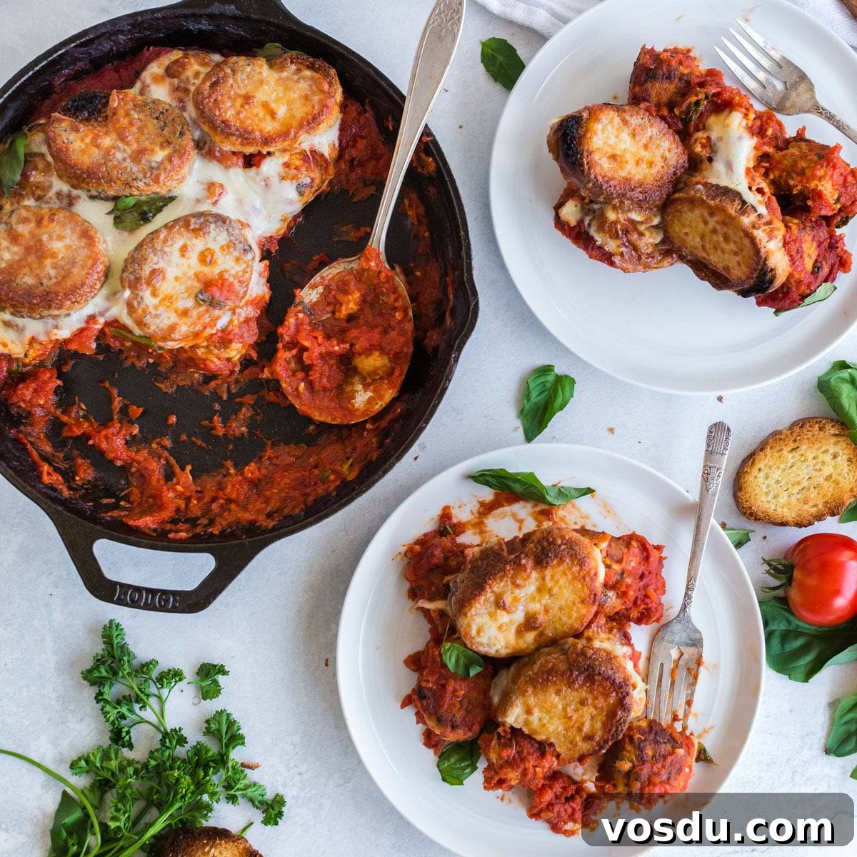Cheesy Chicken Meatball Casserole with Tomato Basil Sauce 5 A skillet and two plates of meatball sub casserole