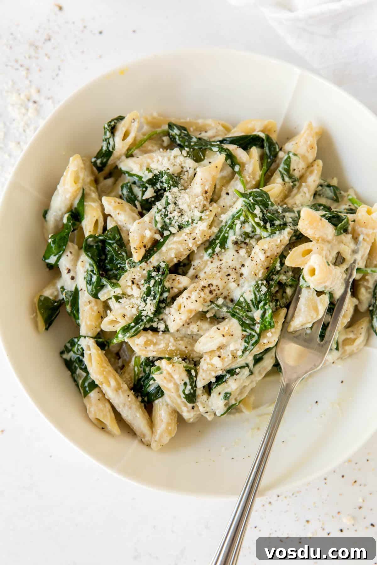 Creamy Spinach and Ricotta Pasta Recipe 5 spinach and ricotta pasta in a white bowl with a fork