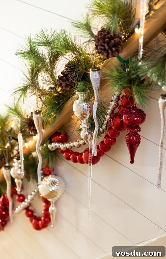 This Year’s Holiday Home Decor: Fresh Ideas to Transform Your Space 11 Red and silver garland and ornaments hanging from a wood banister in stairway