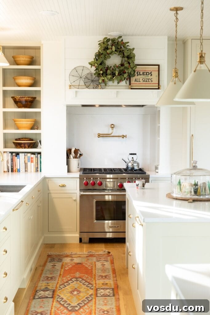 This Year’s Holiday Home Decor: Fresh Ideas to Transform Your Space 20 Inside of white kitchen with large range on far side of wall with white countertops and some greenery above the stove