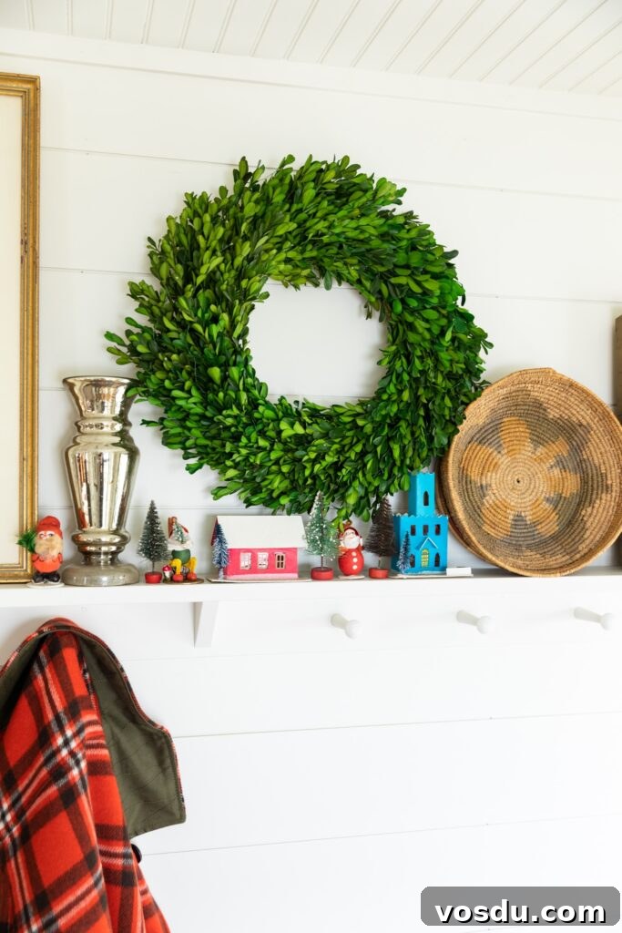 This Year’s Holiday Home Decor: Fresh Ideas to Transform Your Space 3 Shelf holding small Christmas ornaments along with green boxwood wreath, bowl, and picture frame