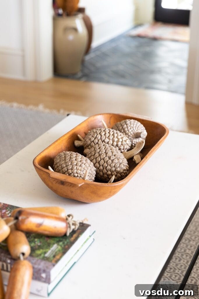 This Year’s Holiday Home Decor: Fresh Ideas to Transform Your Space 7 Marble coffee table with brown wooden bowl filled with sparkling pinecones