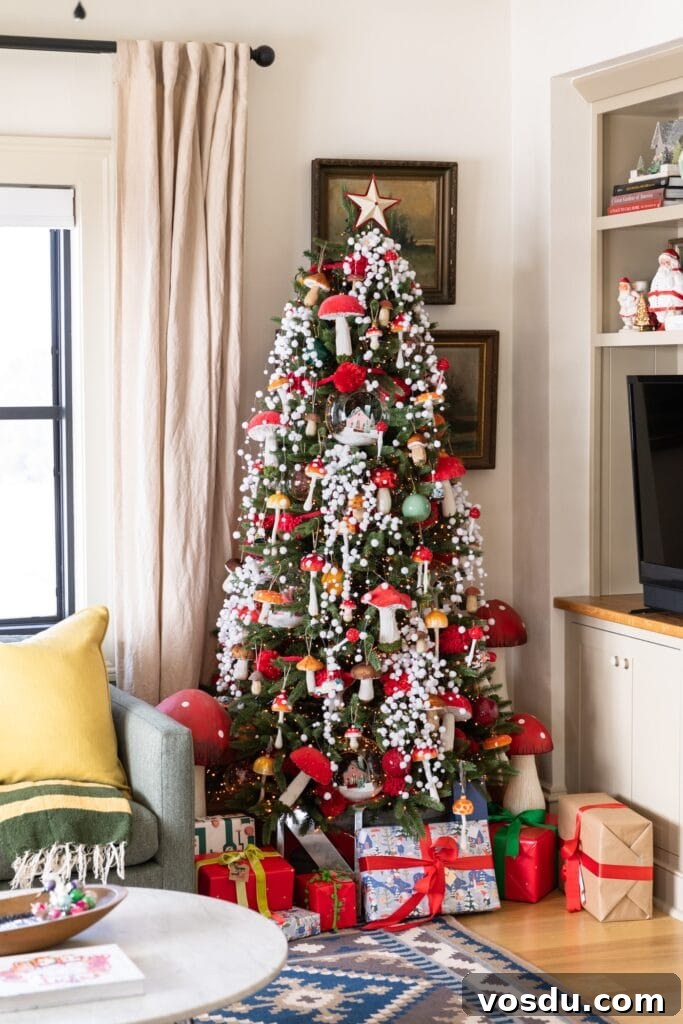 This Year’s Holiday Home Decor: Fresh Ideas to Transform Your Space 8 Large Christmas tree packed with red colored mushrooms and snow garland surrounded by presents on the floor and TV cabinet beside