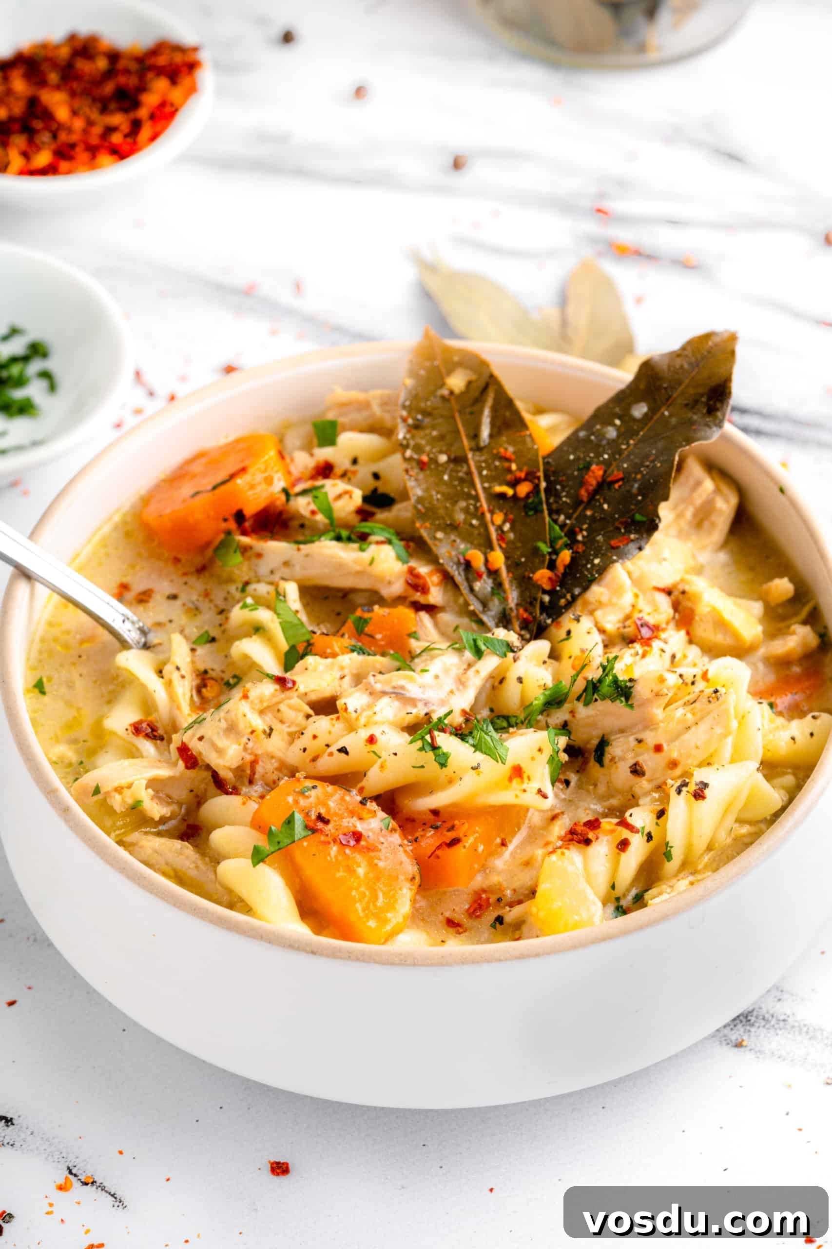 Gluten-Free Chicken Noodle Soup (Dairy-Free) Gluten-free chicken noodle soup in a bowl on a marble board.
