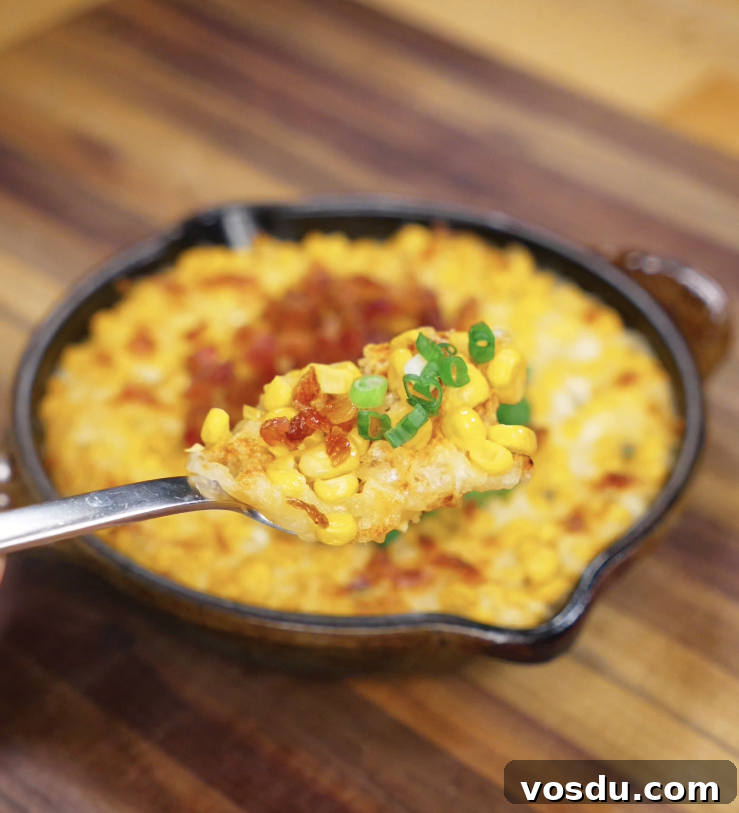 Korean Corn Cheese Recipe: Creamy Cheesy Corn Bake Tutorial 3 A spoonful of hot, melty Korean corn cheese lifted from the pan, showing corn, gooey cheese, and scallion topping.
