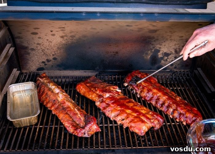 Sticky Mop Sauce for Juicy BBQ Ribs: Simple Homemade Recipe 4 using small bbq mop to apply carolina mop sauce to smoked baby back ribs in pellet grill