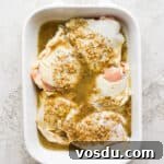Greek-Style Chicken Marinade for Juicy, Flavorful Grilled Chicken 10 A white baking dish filled with raw bone-in, skin-on chicken thighs covered in a Greek chicken marinade.