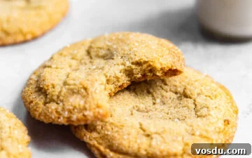 Simple Drop-Style Vanilla Sugar Cookies for Homemade Treats 10 Sugar cookies stacked on top of each other with a bite missing from one next to a glass of milk.