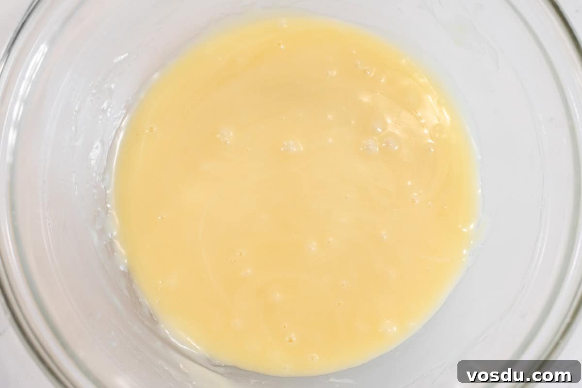 Decadent Oreo Cookie Tart Recipe 8 White chocolate ganache in glass bowl.