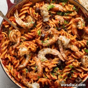 Shrimp Puttanesca Pasta Recipe with Tangy Tomato-Olive Sauce 9 overhead photo of puttanesca with shrimp in a skillet with crusty bread on the side.