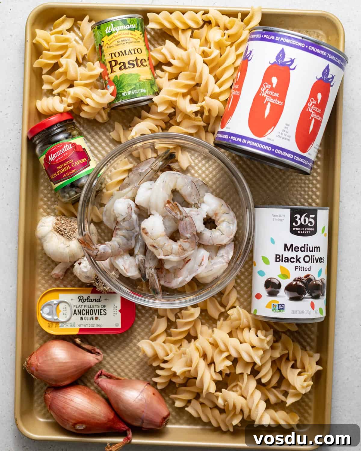 Shrimp Puttanesca Pasta Recipe with Tangy Tomato-Olive Sauce 3 ingredients to make puttanesca with shrimp on a baking sheet.