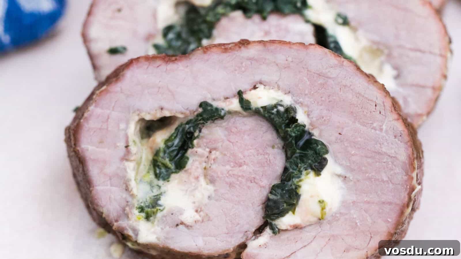 Sliced flank steak stuffed with spinach and cheese on a plate.
