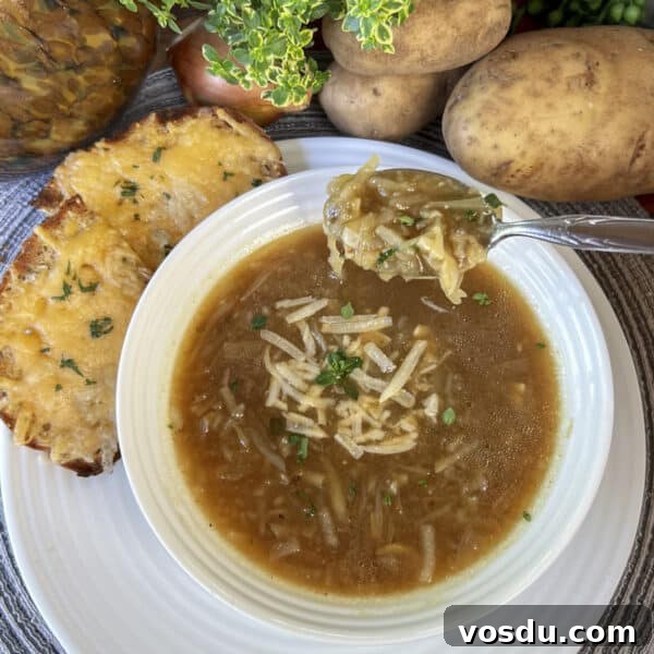potato onion soup in white bowl with spoonful