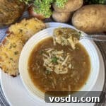 potato onion soup in white bowl with spoonful