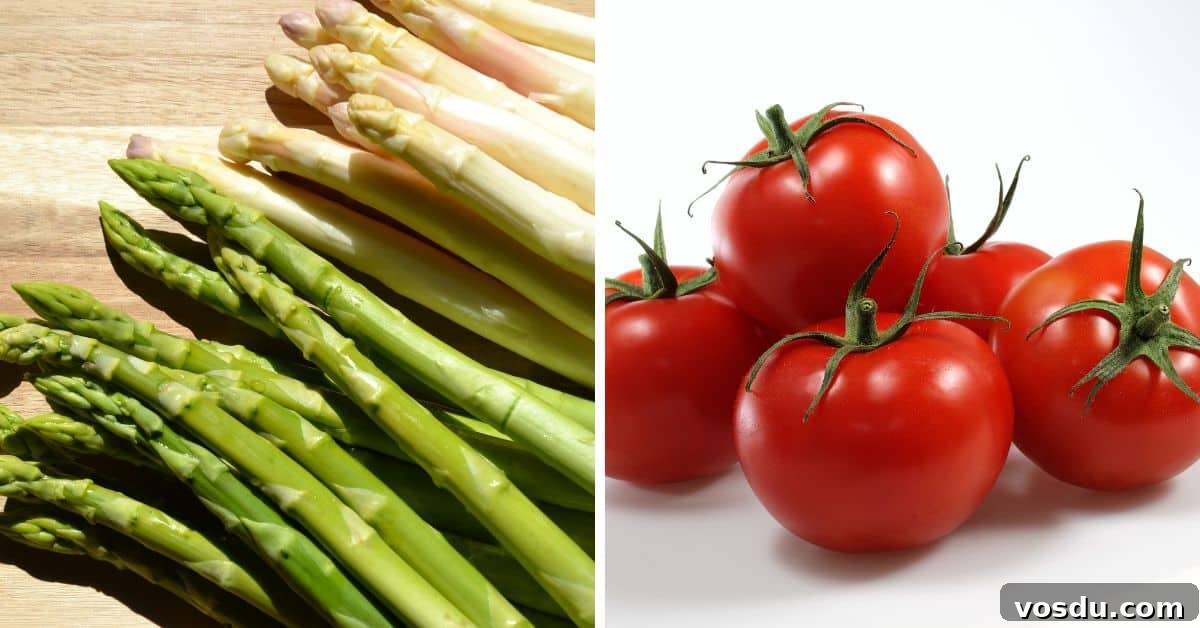 Chilled Asparagus and Tomato Salad with Lemon Vinaigrette 4 Green and white asparagus spears, perfect for a Cold Asparagus Salad, are arranged on a wooden surface beside a group of red tomatoes on a white background.